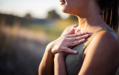 Vrouw met handen op haar borst refereert naar de luchtwegen