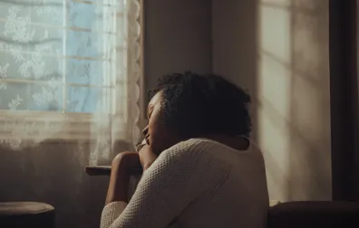 Vrouw bij het raam neerslachtig