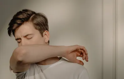 Man hoest in elleboog