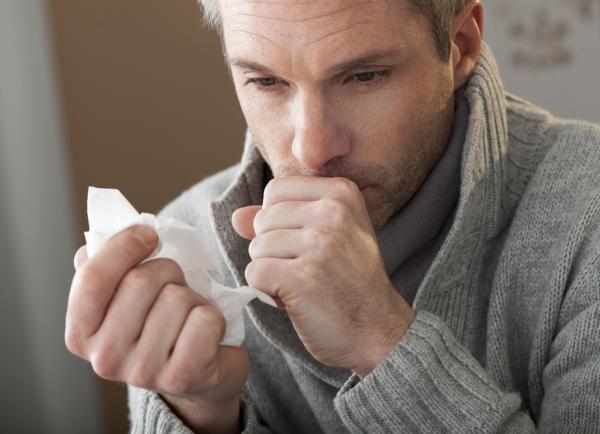 Man hoest met hand voor de mond