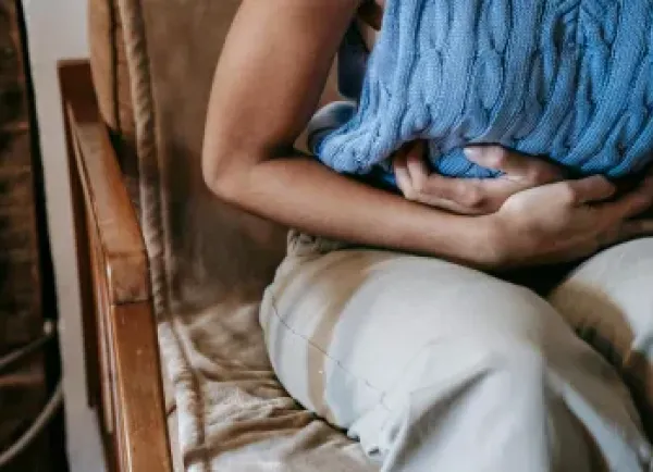 Vrouw houdt handen op buik