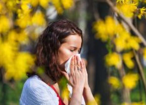 Vrouw snuit neus met op achtergrond bloeiende bomen