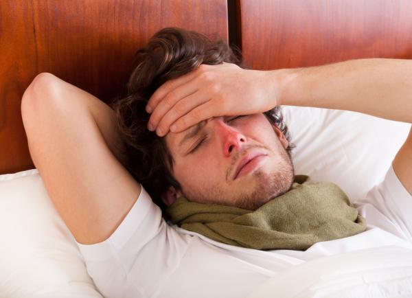 Man ligt ziek in bed